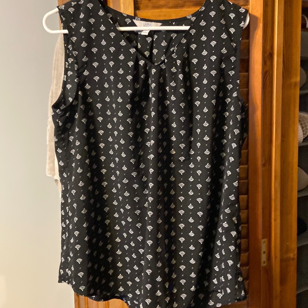 Black sleeveless tunic with white design. Pleated at chest.